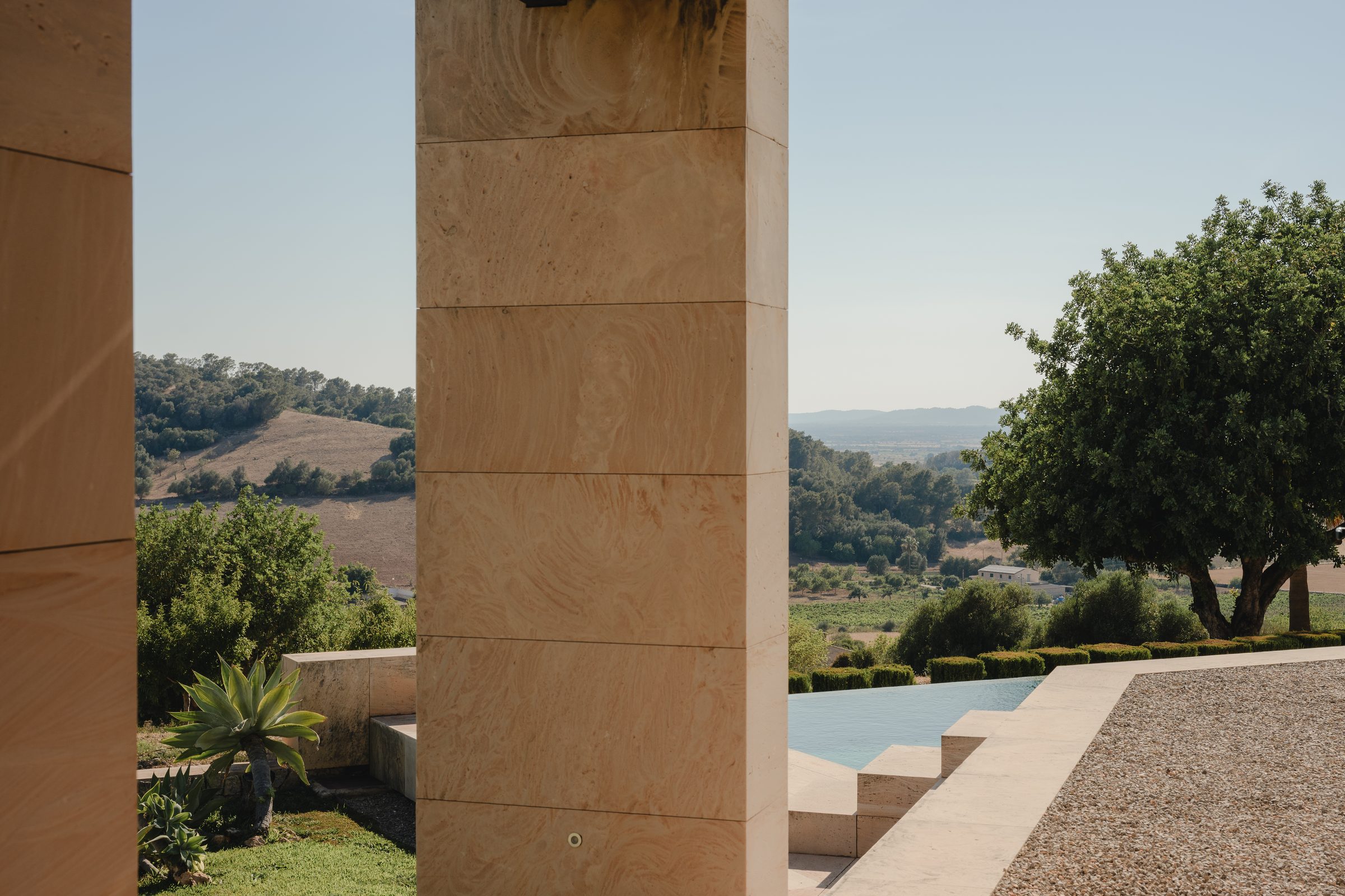 Blick vom überdachten Patio über Pool und Landschaft